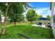 Expansive backyard with a well-maintained lawn, established trees, and a patio set at 7215 Braxton Dr, Noblesville, IN 46062