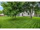Landscaped backyard with a patio, green lawn, mature trees, and a wooden fence at 7215 Braxton Dr, Noblesville, IN 46062