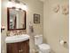 Charming powder room with a vanity, decorative mirror, and neutral color palette at 7215 Braxton Dr, Noblesville, IN 46062