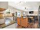 Bright kitchen with granite countertops, an island, stainless steel appliances, and a view into the living room at 7215 Braxton Dr, Noblesville, IN 46062