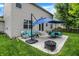Backyard patio features patio furniture, dining set, grill, and blue umbrellas at 7215 Braxton Dr, Noblesville, IN 46062