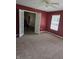 Red living room with white French doors, ceiling fan, carpet, and a window at 7440 Oakview Dr, Avon, IN 46123