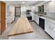 Modern kitchen featuring stainless steel appliances, an island with butcher block countertop, and white cabinetry at 757 Winter Way, Carmel, IN 46032