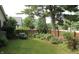 Fenced backyard with lush lawn, mature trees and colorful flower beds at 7662 Micawber Ct, Indianapolis, IN 46256