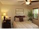 Cozy bedroom features plush bed, dresser with table lamp, and large window at 7662 Micawber Ct, Indianapolis, IN 46256