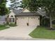 Charming home featuring a large tree, brick accents, and a well-maintained front lawn and two-car attached garage at 7662 Micawber Ct, Indianapolis, IN 46256
