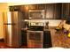 Contemporary kitchen with stainless steel appliances, dark cabinetry, and stylish countertops for a modern look at 7662 Micawber Ct, Indianapolis, IN 46256