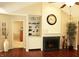Inviting living room with a cozy fireplace, built-in shelving, and elegant hardwood floors for a warm ambiance at 7662 Micawber Ct, Indianapolis, IN 46256
