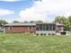 Expansive backyard with green lawn, brick house exterior, and cozy screened-in porch at 784 S Restin Rd, Greenwood, IN 46142
