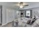 Bright bedroom with wood-look flooring, neutral walls, and a ceiling fan, showing a partial view into the bathroom at 784 S Restin Rd, Greenwood, IN 46142