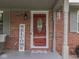 Charming front entryway with a red door, decorative welcome sign, and classic brick accents at 784 S Restin Rd, Greenwood, IN 46142