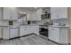 The kitchen features white cabinets, stainless steel appliances, mosaic backsplash, and modern gray wood flooring at 784 S Restin Rd, Greenwood, IN 46142
