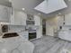 Bright eat-in kitchen features a skylight, white cabinets, stainless appliances, and modern gray wood flooring at 784 S Restin Rd, Greenwood, IN 46142