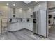 Eat-in kitchen features a modern stainless refrigerator, white cabinets, mosaic backsplash, and gray wood flooring at 784 S Restin Rd, Greenwood, IN 46142