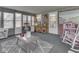 Cozy sunroom with brick accent walls, a comfortable rocking chair, a dollhouse, and multiple windows at 784 S Restin Rd, Greenwood, IN 46142