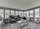 A cozy sunroom with a comfortable reclining sofa, wicker table, and multiple windows for abundant natural light at 784 S Restin Rd, Greenwood, IN 46142