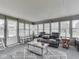 Bright sunroom with multiple windows, a comfortable reclining sofa, wicker table, and a white rocking chair at 784 S Restin Rd, Greenwood, IN 46142