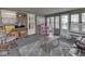Bright sunroom featuring multiple windows, a rocking chair, a dollhouse, and a comfortable reclining sofa at 784 S Restin Rd, Greenwood, IN 46142
