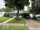 Charming single-story home featuring a covered carport and mature landscaping at 7918 Bonita Ct, Indianapolis, IN 46219