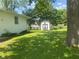 Backyard view featuring a white shed, lush grass, and mature trees providing a private outdoor space at 8008 Cherington Dr, Indianapolis, IN 46227