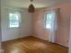 Bright bedroom with hardwood floors, featuring two windows and charming floral accents on the wall at 8008 Cherington Dr, Indianapolis, IN 46227