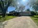 Charming exterior featuring a white brick facade, attached garage, and well-maintained front lawn at 8008 Cherington Dr, Indianapolis, IN 46227