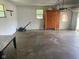 Spacious garage featuring ample storage with a cabinet, a lawn mower, and natural lighting from windows at 8008 Cherington Dr, Indianapolis, IN 46227