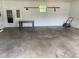 Spacious garage featuring a lawn mower, a work bench, and natural light from windows, offering room for projects at 8008 Cherington Dr, Indianapolis, IN 46227