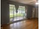 Living room with hardwood floors, ceiling fan, gray walls, and large window with light curtains at 8008 Cherington Dr, Indianapolis, IN 46227