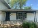 White brick house with a black beam porch, black columns, a bay window, and flowers in front at 8008 Cherington Dr, Indianapolis, IN 46227