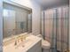 Bathroom features a vanity, toilet, mirror, and shower with a curtain at 8315 Union Chapel Rd, Indianapolis, IN 46240