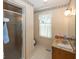 Neutral-toned bathroom with striped walls, window, and glass enclosed shower at 8315 Union Chapel Rd, Indianapolis, IN 46240