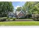 Charming brick and green two-story home with mature trees and manicured landscaping at 8315 Union Chapel Rd, Indianapolis, IN 46240
