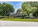 Charming brick and green two-story home with mature trees and manicured landscaping at 8315 Union Chapel Rd, Indianapolis, IN 46240