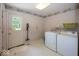 Laundry room with washer, dryer, floral wallpaper, and door to outside at 8315 Union Chapel Rd, Indianapolis, IN 46240