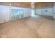 Expansive living room featuring wood-paneled ceiling, sliding doors to outside, and neutral carpeting at 8315 Union Chapel Rd, Indianapolis, IN 46240