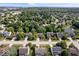 This eye-level aerial view showcases a neighborhood's well-maintained homes, lush greenery, and a tranquil pond at 8827 Lindsey Ct, Fishers, IN 46038
