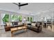 Comfortable living room featuring a ceiling fan, large windows, and open access to the kitchen and dining area at 8827 Lindsey Ct, Fishers, IN 46038
