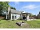 A backyard features a stone fire pit, chimney, and deck with grill at 8929 Sunburst Cir, Indianapolis, IN 46227