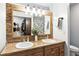 Bathroom with double sink vanity, framed mirror, and closet access at 8929 Sunburst Cir, Indianapolis, IN 46227