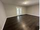 Bright living room with dark floors, neutral walls and a glass paneled door to the backyard at 952 Delray Dr, Indianapolis, IN 46241