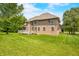A sprawling brick house with a well-maintained lawn, a spacious backyard, and mature trees at 1008 Westcreek Dr, Columbus, IN 47201