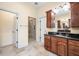 Well-lit bathroom featuring a tiled shower, wood cabinets, and black granite countertops at 1008 Westcreek Dr, Columbus, IN 47201