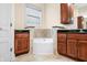 Bathroom area featuring wood cabinets with granite countertops and a corner tub at 1008 Westcreek Dr, Columbus, IN 47201