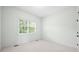 Neutral bedroom with a window, carpet flooring, base trim and a white door at 1008 Westcreek Dr, Columbus, IN 47201
