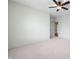 Light and airy bedroom with neutral carpet, ceiling fan, and view into another room at 1008 Westcreek Dr, Columbus, IN 47201