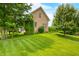 Well-maintained brick home showcases a lush lawn and mature trees in a serene setting at 1008 Westcreek Dr, Columbus, IN 47201