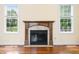 A detailed shot of a classic fireplace with wooden mantle and tile surround, flanked by bright windows at 1008 Westcreek Dr, Columbus, IN 47201