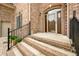 Charming brick home featuring an arched doorway with black metal railing and manicured landscaping at 1008 Westcreek Dr, Columbus, IN 47201