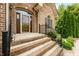 Charming brick home featuring an arched doorway, glass storm door and manicured landscaping at 1008 Westcreek Dr, Columbus, IN 47201